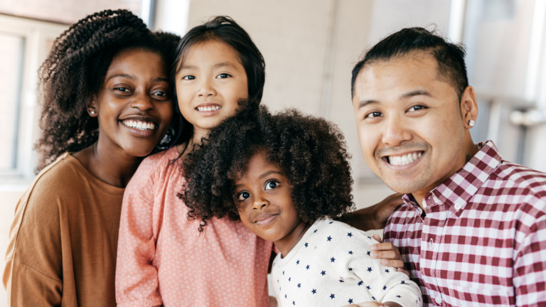 mom dad and 2 little girls smiling